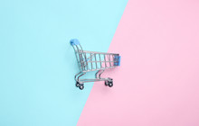 Mini Shopping Trolley For Shopping On A Colored Pastel Background, Consumer Concept, Minimalism, Top View..
