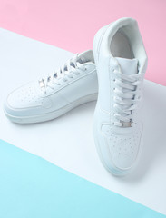 Wall Mural - Fashionable white sneakers on a colored pastel background, minimalism, top view, creative layout.