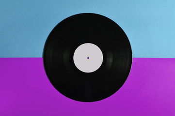 Vinyl plate on a colored background, retro music technology, top view, minimalism.