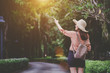 Young woman traveler with a backpack and enjoy photography, travel girl outdoors. Nature walkway.