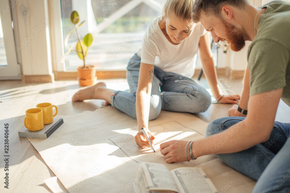 Portrait of happy caucsian couple planning new house design looking at paper - obrazy, fototapety, plakaty 