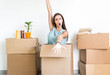 © Davide Angelini - Portrait of a happy beatiful girl moving in the new house and unboxing cardboard