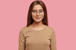 © WHstudio Leushin N - Photo of pleasant looking girl has healthy soft skin, dark staright hair, dressed in casual sweater, looks directly at camera, models against pink background. People, beauty and facial expressions