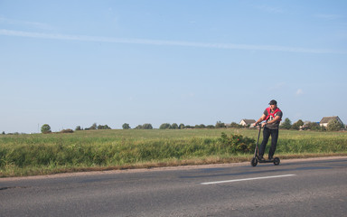 Young man riding an electric scooter