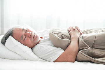 Senior man sleeping in bed.