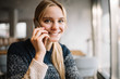 © Oleksii - Portrait of attractive smiling woman with beautiful face sitting in modern cafe using mobile phone. Young successful female calling mobile.