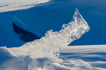 Transparent piece of ice on the snow