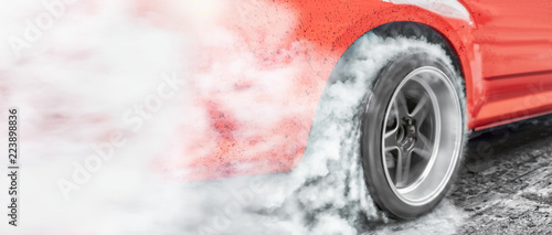 Fotografía Drag racing car burns rubber off its tires in preparation for the race