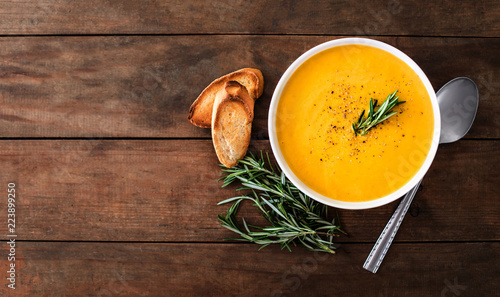 Fotomural Pumpkin and carrot Cream soup on rustic wooden table