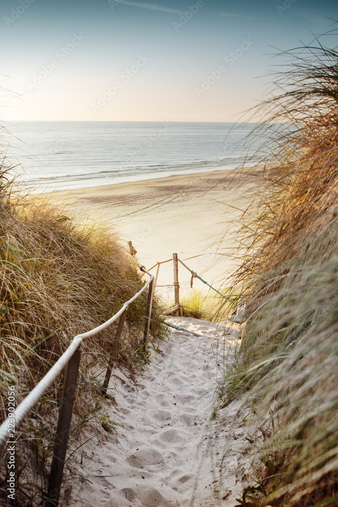 Walking down to the beach with sea overview at the evening enjoying sunset light. Best place to spent after a summer day. Løkken in North Jutland in Denmark, Skagerrak, North Sea - obrazy, fototapety, plakaty 