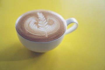 latte art on yellow cafe table, coffee cafe