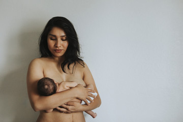 Wall Mural - naked mother holding her newborn baby
