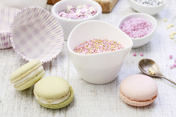 Wall Mural - Woman prepares muffins decorated with cream and sprinkles.