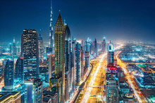 Spectacular Urban Skyline With Colourful City Illuminations. Aerial View On Highways And Skyscrapers Of Dubai, United Arab Emirates.
