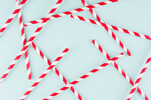 Abstract Modern Fashion Background - Red And White Striped Straws As Random Pattern On Light Mint Background.