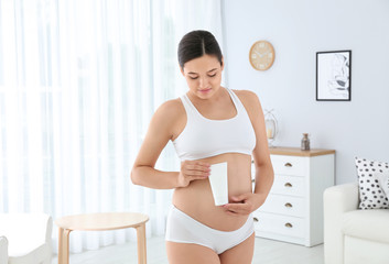 Sticker - Pregnant woman holding body cream at home