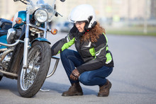 Woman Biker Trying To Repair Flat Tire On Motorcycle At City Asphalt Road