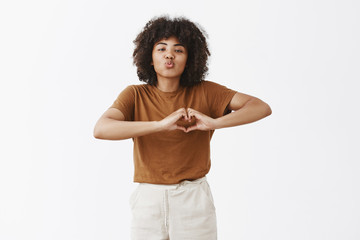 Wall Mural - love you my cutie. portrait of tender and joyful cute dark-skinned woman with curly hair folding lip
