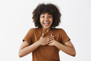 Wall Mural - surprised and greatful attractive tender african american woman in trendy brown t-shirt holding hand