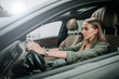 © Yakobchuk Olena - Side view focused woman holding steering wheel while sitting in cozy salon of automobile. Undistracted girl going at work concept