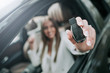© Yakobchuk Olena - I am buying it. Portrait of cheerful female holding key of car while sitting there. She demonstrating it in hands for camera