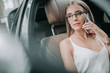 © Yakobchuk Olena - Portrait of pensive lady in glasses speaking on phone while locating in cabin of contemporary car