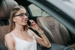 © Yakobchuk Olena - Portrait of beaming female employer talking on mobile while resting on cozy chair in comfortable vehicle