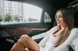 © Yakobchuk Olena - Side view cheerful girl having leisure while watching at street from modern vehicle. Glad female employer during relax in automobile concept