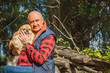 © T.Den_Team - Senior man with his pet little red pekingese dog at home yard. American mature man with a dog. Concept of Life animals and human