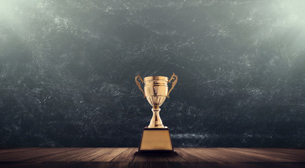 champion golden trophy placed on wooden table with blackboard background copy space ready for your d