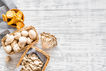 Wall Mural - Collect mushroom concept. Champignons, oysters, chanterelles in basket near knife on grey background top view copy space