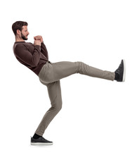 An Isolated Bearded Man In Casual Clothes Stands On White Background In The Middle Of Leg Kick.