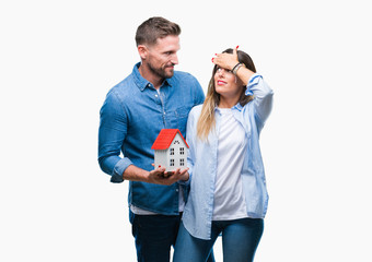 Poster - Young couple in love holding house over isolated background stressed with hand on head, shocked with shame and surprise face, angry and frustrated. Fear and upset for mistake.