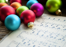 Alte Handgeschriebene Musiknoten Mit Bunten Weihnachtskugeln Auf Holz / Treiholz Hintergrund, Weihnachten, Xmas 