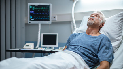 In the Hospital Senior Patient Rests, Lying on the Bed. Recovering Man Sleeping in the Modern Hospital Ward.