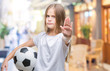 © Krakenimages.com - Young beautiful girl holding soccer football ball over isolated background with open hand doing stop sign with serious and confident expression, defense gesture