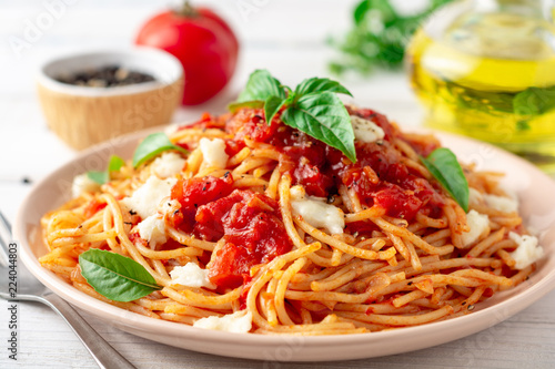 Cuadros en Lienzo Spaghetti pasta with tomato sauce, mozzarella cheese and fresh basil in plate on white wooden background