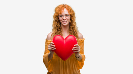 Sticker - Young redhead woman in love holding red heart with a happy face standing and smiling with a confident smile showing teeth