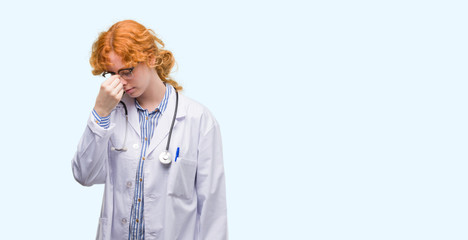 Wall Mural - Young redhead woman wearing doctor uniform tired rubbing nose and eyes feeling fatigue and headache. Stress and frustration concept.