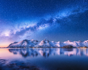 Wall Mural - bright milky way over snow covered mountains and sea at night in winter in norway. landscape with sn