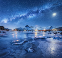 Wall Mural - milky way above frozen sea coast, snow covered mountains and starry sky with moon in winter at night