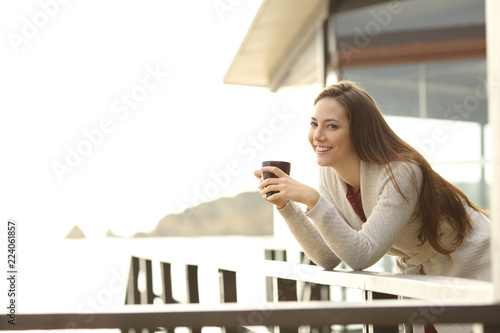 Plakat Szczęśliwy hotelowy gość trzyma kawę patrzy na ciebie