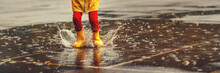 Legs Of Child   With Rubber Boots Jump In Puddle  On Autumn Walk