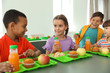 © New Africa - Children sitting at table and eating healthy food during break at school