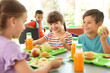 © New Africa - Children sitting at table and eating healthy food during break at school