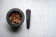 Stone pestle and mortar with pecan nuts on neutral background