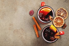 Two Cups Of Christmas Mulled Wine Or Gluhwein With Spices And Orange Slices On Rustic Table Top View. Traditional Drink On Winter Holiday. Top View With Copy Space