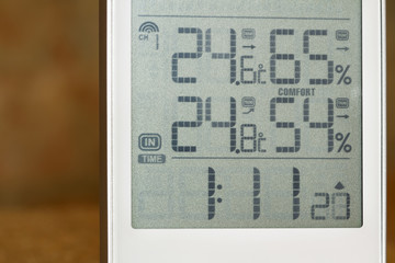 Wall Mural - Home weather station device with weather conditions inside and outside on a brick background. Closeup, selective focus