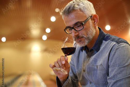 Fotografía Winemaker tasting red wine in cellar