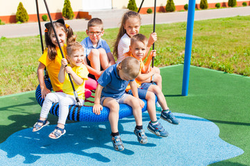 Friendly group on the swing in the summer outdoors